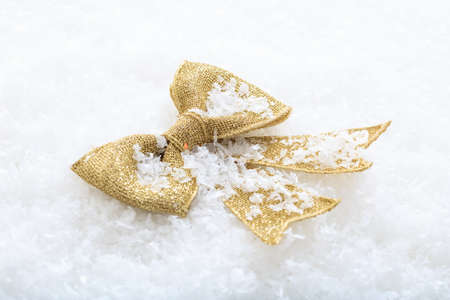 Golden bow on snow backgroundの写真素材