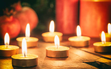 Candles and dry pomegranates on a wooden backgroundの写真素材