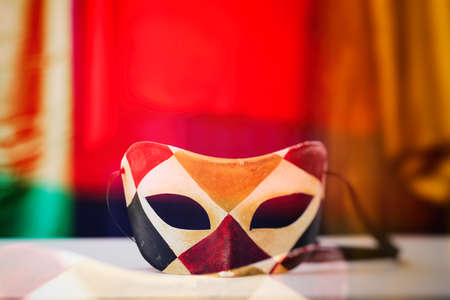 Venetian harlequin carnival mask on colorful backgroundの写真素材