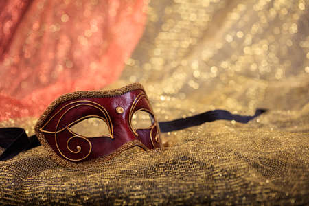 Red carnival mask isolated on golden blur backgroundの写真素材