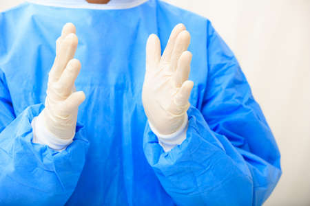 Surgeon wearing latex gloves on white background