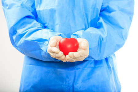 Doctor holding a heart standing on white backgroundの写真素材