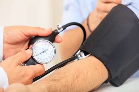 Doctor measuring blood pressure of a patient