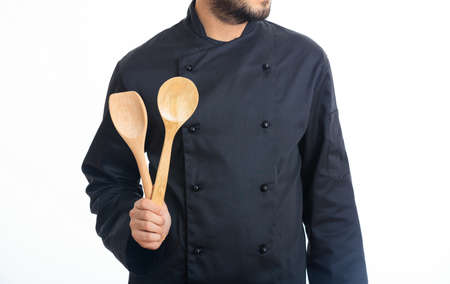 Chef holding wooden spoons isolated on white backgroundの写真素材