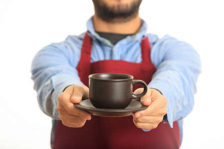 Young man offering a cup of coffee on white background