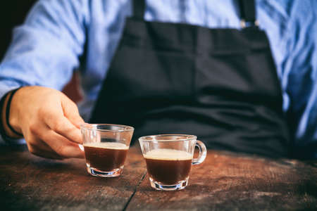 Young man and two cups of espressoの写真素材