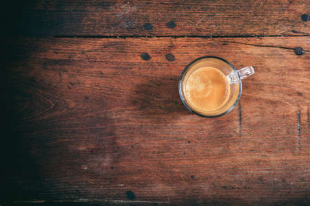 Transparent cup of espresso on a wooden tableの写真素材