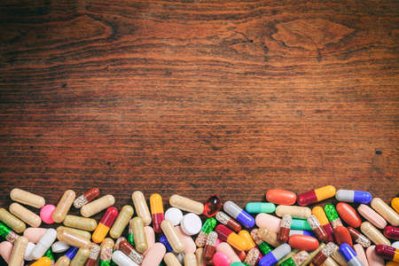 Colorful capsules on a wooden background with copy spaceの写真素材