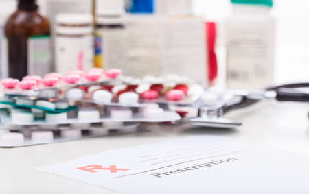 Packs of pills and a stethoscope on white backgroundの写真素材