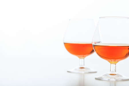 Two crystal cognac glasses on white backgroundの写真素材