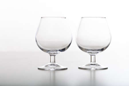 Two empty crystal cognac glasses on white backgroundの写真素材