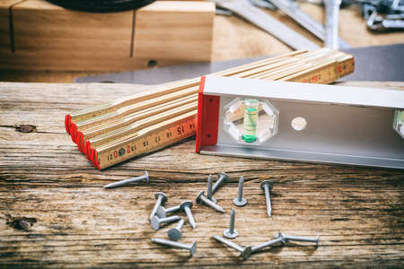 Hand tools and nails on a wooden bench