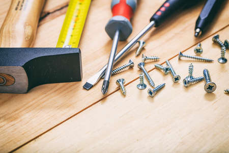 Hammer and screwdrivers on a wooden bench
