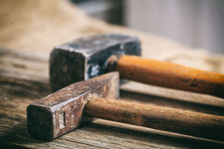 Two olld hammers on a wooden tableの写真素材