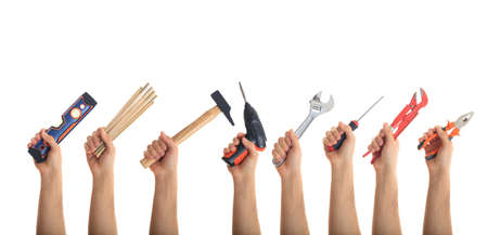 Hands holding hand tools on white backgroundの写真素材