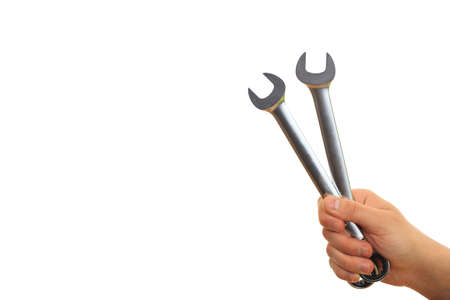 Hand holding two spanners on white backgroundの写真素材