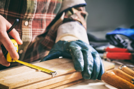 Carpenter holding a measure tape on the work benchの写真素材