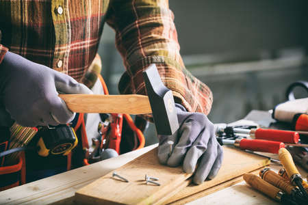 Carpenter working with a hammer on the work benchの写真素材