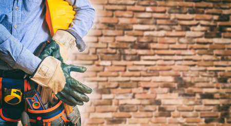 Worker with safety equipment on brick wall backgroundの写真素材