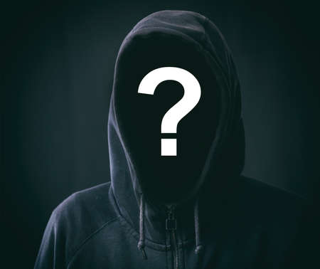 Hooded faceless man on black backgroundの写真素材