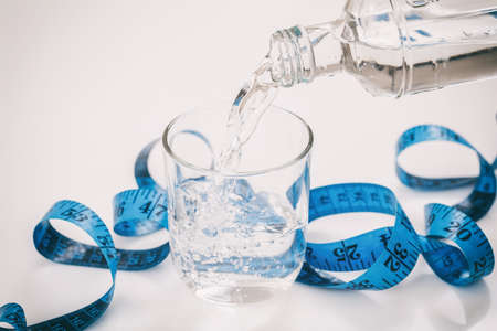 Water and measuring tape on white backgroundの写真素材