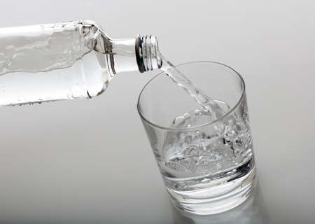 Glass and bottle of water on white backgroundの写真素材