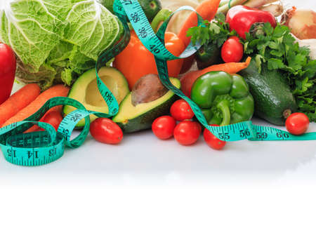 Variety of fresh vegetables and measure tape on white backgroundの写真素材