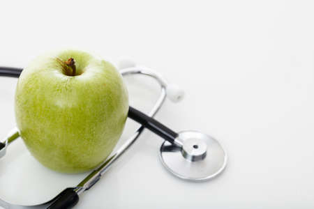 Apple and stethoscope on white backgroundの写真素材