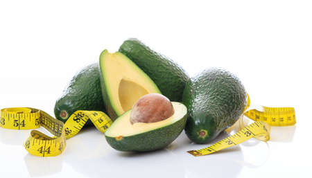Avocados and measure tape on white backgroundの写真素材