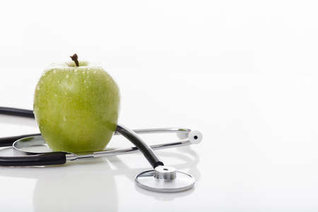 Apple and stethoscope on white backgroundの写真素材