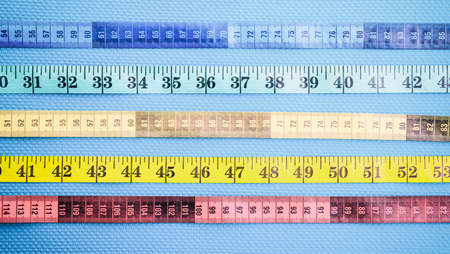 Set of colorful measure tapes on a blue backgroundの写真素材
