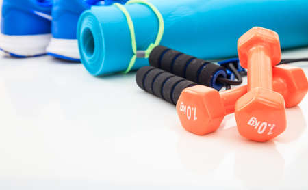 Yoga mat and dumbbells on white backgroundの写真素材