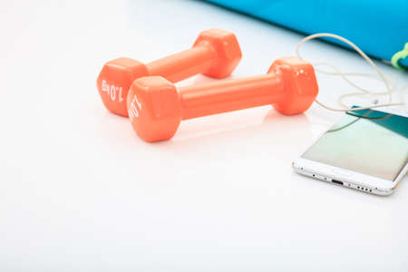 Yoga mat and dumbbells on white backgroundの写真素材