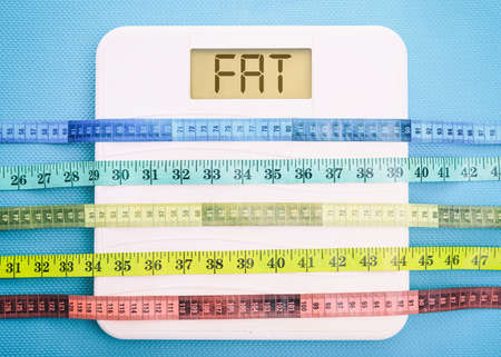 Bathroom scale and measure tapes on a blue backgroundの写真素材