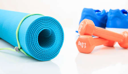 Yoga mat and dumbbells on white backgroundの写真素材