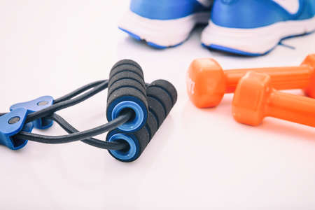 Expander and dumbbells on white background