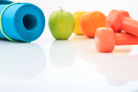 Yoga mat and dumbbells on white backgroundの写真素材