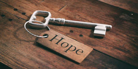 Old metal key with label hope on a wooden background. 3d illustrationの写真素材