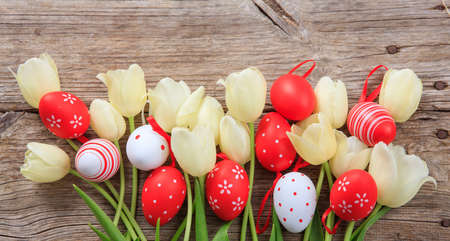 Easter eggs and tulips on wooden background with copy spaceの写真素材