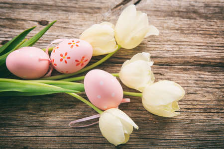 Easter eggs and tulips on wooden background with copy spaceの写真素材