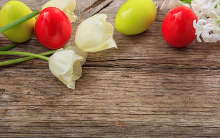 Easter eggs and tulips on wooden background with copy spaceの写真素材