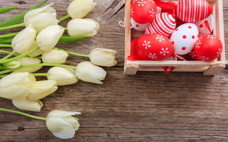 Easter eggs and tulips on wooden background with copy spaceの写真素材