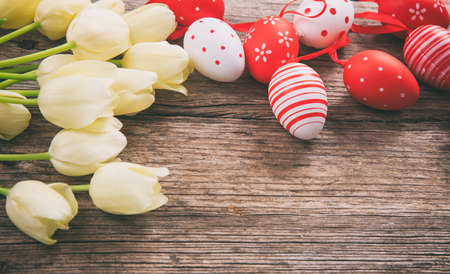Easter eggs and tulips on wooden background with copy spaceの写真素材