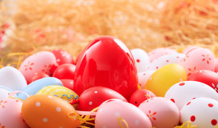 Colorful pastel Easter eggs on straw backgroundの写真素材