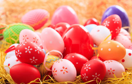 Colorful pastel Easter eggs on straw backgroundの写真素材