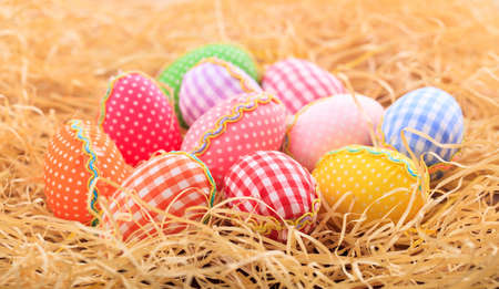 Colorful pastel Easter eggs on straw backgroundの写真素材