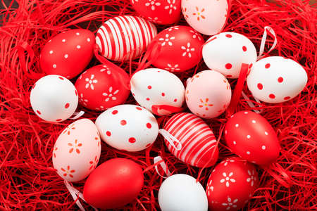 Colorful Easter eggs in a basket on straw backgroundの写真素材