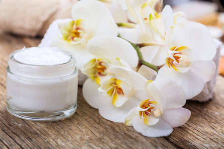 Moisturizing cream and white orchid on wooden backgroundの写真素材