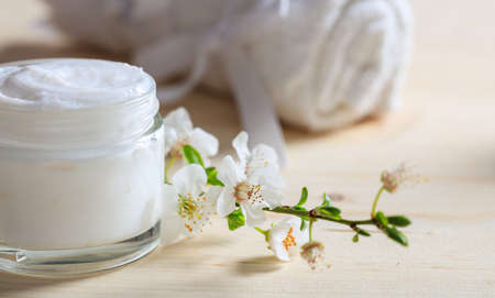 Moisturizing cream and almond blossoms on wooden backgroundの写真素材