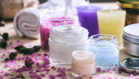 Variety of creams and bath salt on wooden background